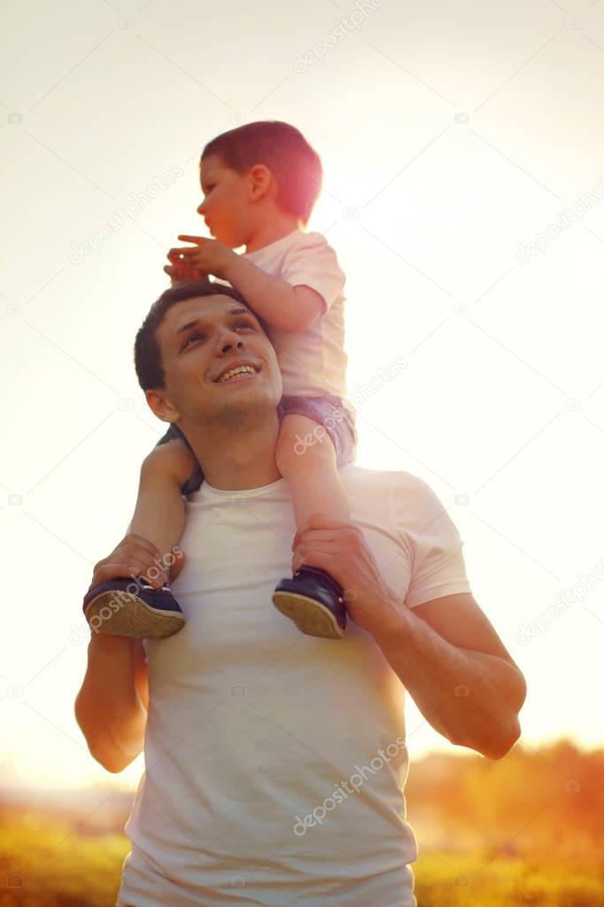 Happy father and little child son walking at sunny day, family p