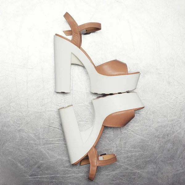 Gümüş dokulu bir arka plan üzerinde moda yüksek topuklu ayakkabı