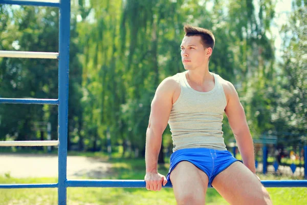 Sport, street workout concept - sportsman sitting on the horizon