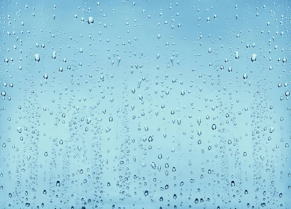 Texture drops of water on a transparent glass blue background — Stock Photo, Image