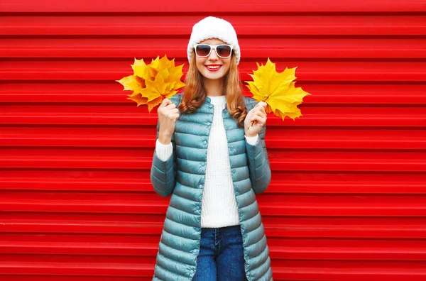 Moda outono sorridente mulher mantém um bordo amarelo folhas na mão — Fotografia de Stock