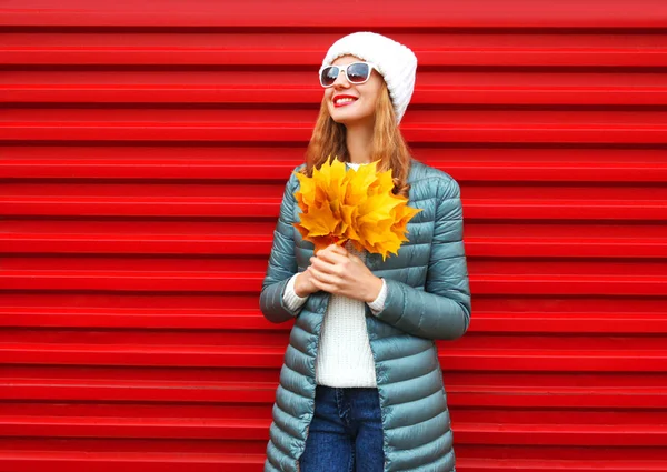 Moda otoño sonriente mujer sostiene hojas de arce amarillo en las manos — Foto de Stock