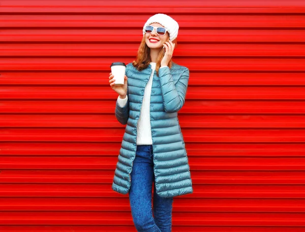 Moda sonriente mujer habla en un teléfono inteligente sostiene taza de café en —  Fotos de Stock