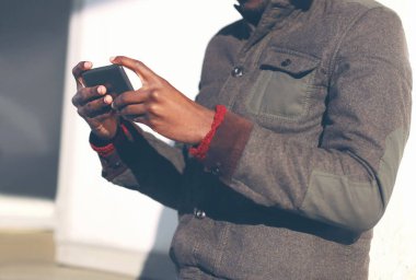 Afrika delikanlı closeup şehirde bir smartphone kullanarak han