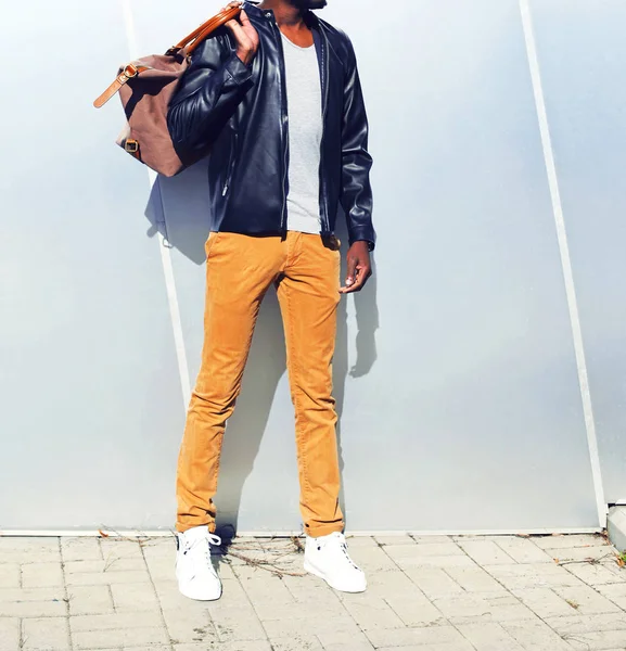Fashion african man in a black leather jacket with a bag in the — Stock Photo, Image
