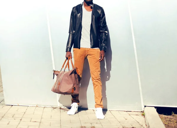 Fashion mand i en sort læderjakke med taske i byen - Stock-foto