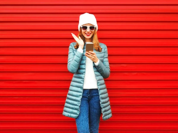 Mujer emocional feliz se ríe con un teléfono inteligente en un bac rojo — Foto de Stock