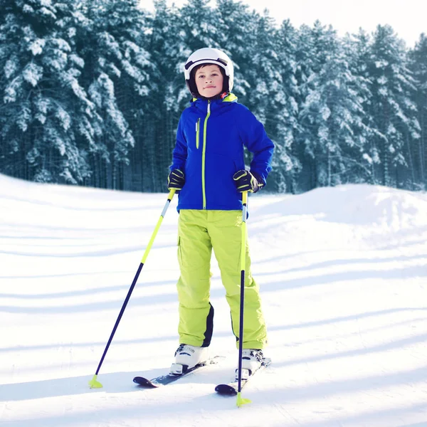 Professional skier child wearing a sportswear with skis in winte — Stock Photo, Image