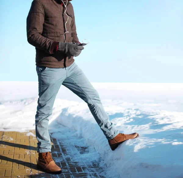 冬ファッション アフリカ男は、上スマート フォンで音楽を聴いてください。 — ストック写真