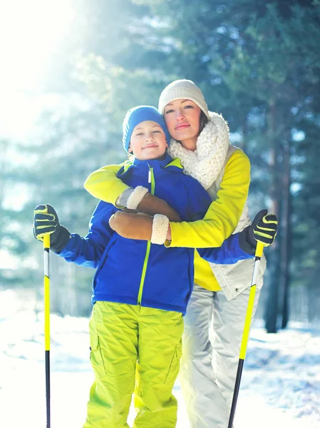 Winter portrait of mother hugs her son child on a ski in the for — Stock Photo, Image