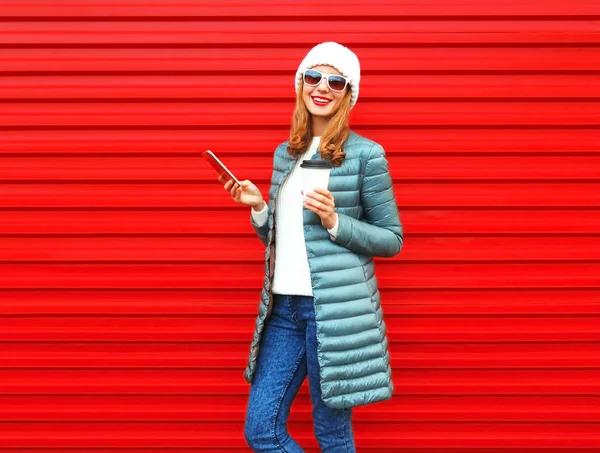 Moda joven mujer sonriente usando teléfono inteligente con taza de café en — Foto de Stock