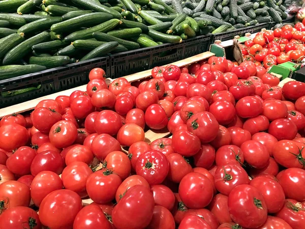 Muchos tomates rojos y pepinos en el supermercado —  Fotos de Stock