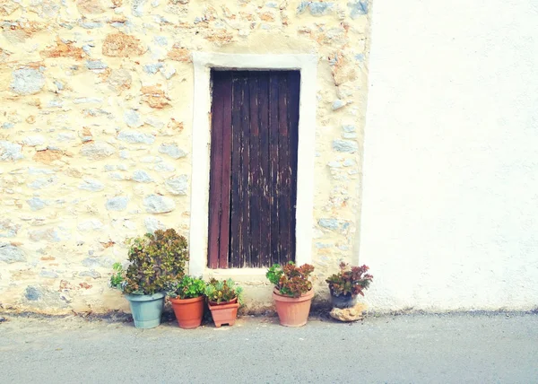 Blumentöpfe und alte Holztür in einer kleinen gemütlichen Straße — Stockfoto