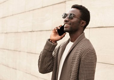 Portre mutlu gülümseyen Afrikalı adam akıllı telefondan arıyor.