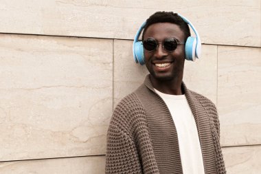 Kablosuz kulaklık listesindeki gülümseyen Afrikalı adam.
