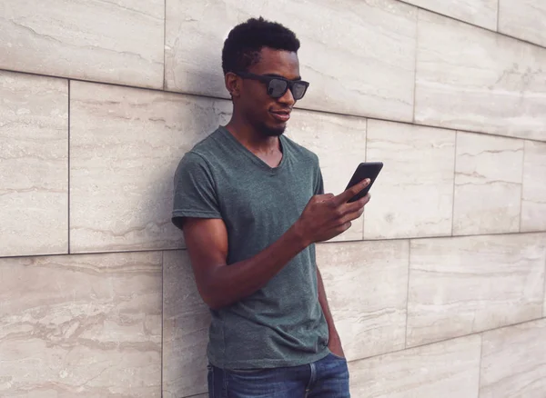Portret młodego Afrykanina z telefonem w koszulce, sunglasse — Zdjęcie stockowe