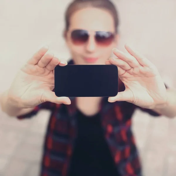 Cerca de manos femeninas sosteniendo el teléfono en blanco negro de la pantalla, mujer ta — Foto de Stock