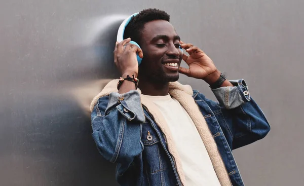Heureux homme africain souriant dans les écouteurs sans fil écouter mu — Photo