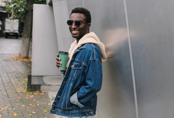 Porträt eines glücklich lächelnden Afrikaners mit Kaffeetasse beim Spaziergang — Stockfoto