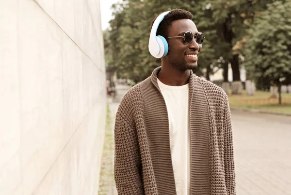 Portrait stylish smiling african man in wireless headphones list — ストック写真