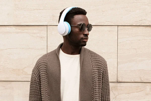 Portrait stylish african man in wireless headphones listening to — ストック写真