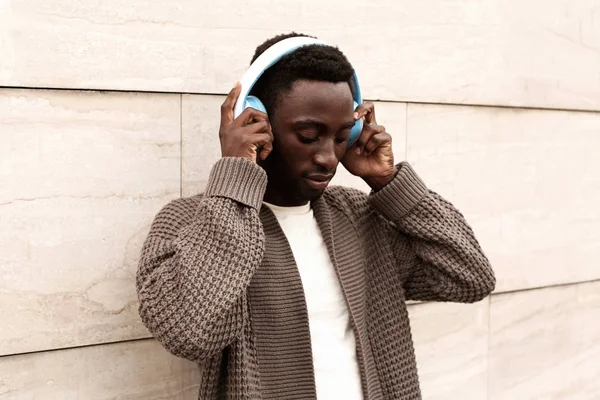 Retrato elegante homem africano em fones de ouvido sem fio ouvindo — Fotografia de Stock