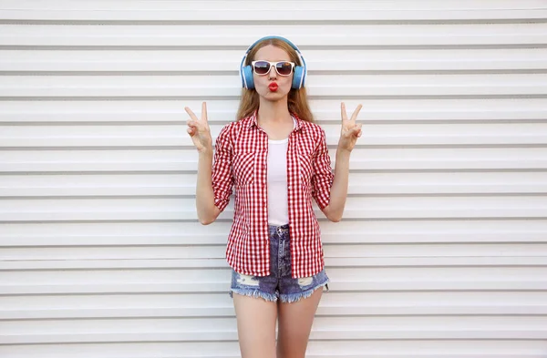 Kulaklıklı Çekici Genç Bir Kadın Müzik Dinliyor Kırmızı Dudaklar Üflüyor — Stok fotoğraf