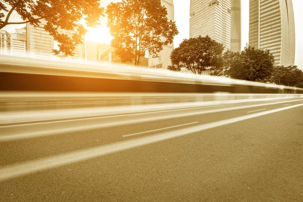 Viel befahrene Asphaltstraße in der modernen Stadt im Zwielicht — Stockfoto