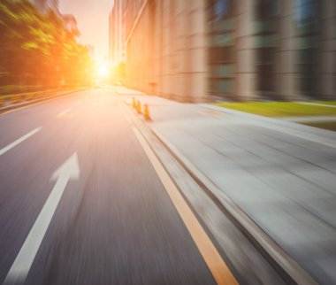 Modern şehirde alacakaranlık altında asfalt yol meşgul.