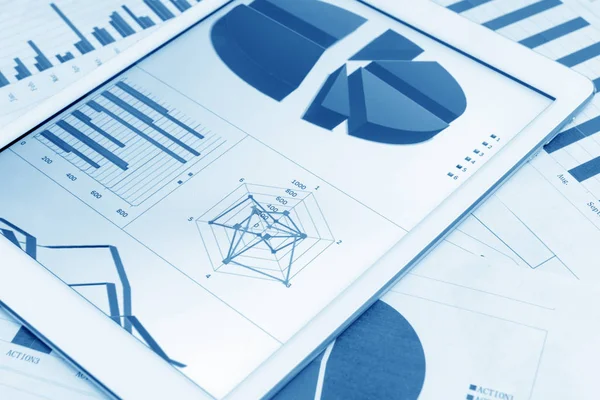 Gráficos financieros sobre la mesa con tableta Fotos De Stock Sin Royalties Gratis