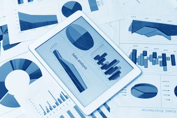 Финансовые диаграммы на столе с планшетом — стоковое фото