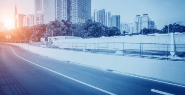 Modern şehirde Zebra geçidi ve gökdelenleri olan boş bir yol.