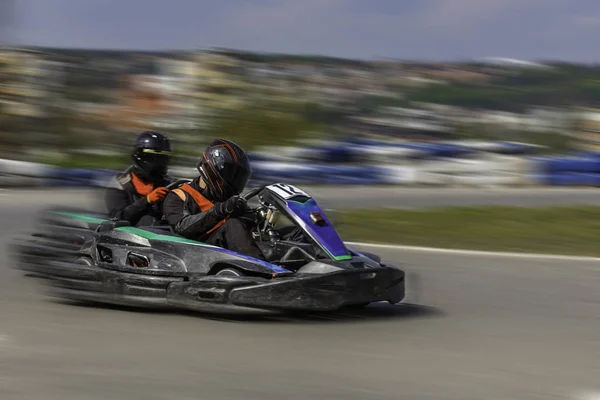 Karting Championship. Driver i karting bär hjälm, racing suit deltar i kart race. Karting Visa. Barn, vuxen åkare karting. — Stockfoto