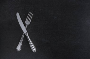 Menü için siyah kara tahta arka plan üstten görünüm üstten görünüm şablonundaki çatal ve bıçak çatal