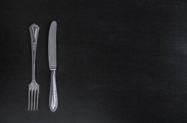 Menü için siyah kara tahta arka plan üstten görünüm üstten görünüm şablonundaki çatal ve bıçak çatal