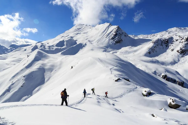 Bir grup insan kar ayakkabıları ve dağ kar panorama Stubai Alps, Avusturya için mavi gökyüzü ile hiking
