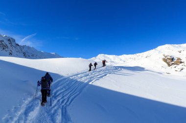 Bir grup insan kar ayakkabıları ve dağ kar panorama Stubai Alps, Avusturya için mavi gökyüzü ile hiking