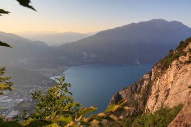 Bir Riva del Garda şehir panorama adlı Garda Gölü ve dağlar, gündoğumu sabah, İtalya