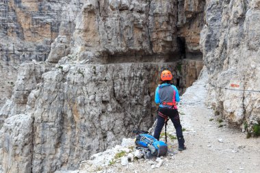 Ferrata Sentiero delle Bocchette Centrale aracılığıyla, İtalya 'nın Brenta Dolomites dağlarında tek başına duran bir kadın.