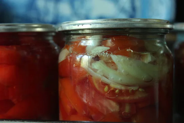 Jars with tomatoes. Conservation and cooking on kitchen.