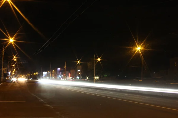 El movimiento borroso de las luces del coche en la carretera por la noche carretera - foto de larga exposición —  Fotos de Stock