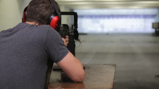 Man is aiming a gun in the shooting-range in shooting gallery — Stock Video
