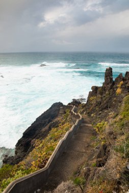 garachico Atlantik Okyanusu ve mavi gökyüzü üzerinde manzaralı town yakınındaki boş kayalar merdivende