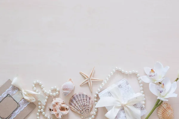 Present, beads, seashells, orchid and space for text on wooden background — Stock Photo, Image