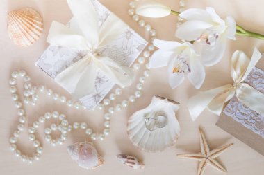 Hediye, boncuk, deniz kabuğu, orkide ve yüzük ahşap arka plan üzerinde