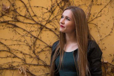 Ivy ile sarı duvar yanında modern genç kadın