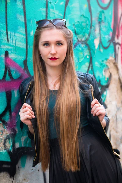 Joven mujer moderna junto a la pared de graffiti — Foto de Stock