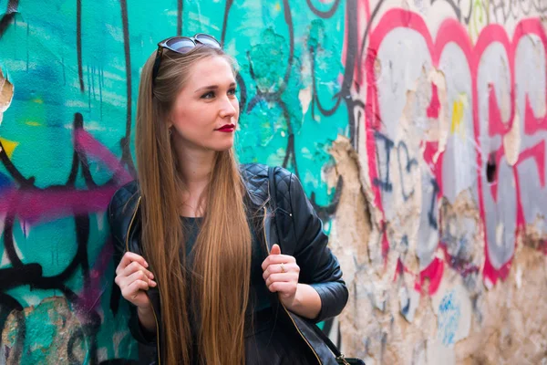 Jeune femme moderne à côté du mur de graffiti — Photo