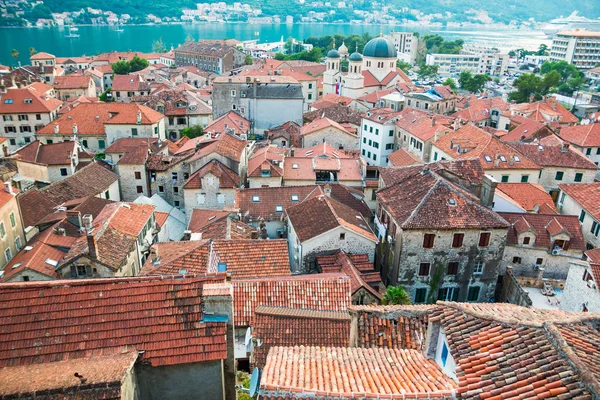 Vista de telhados de azulejos da cidade velha ang a igreja da fortaleza na colina em Kotor em Montenegro — Fotografia de Stock