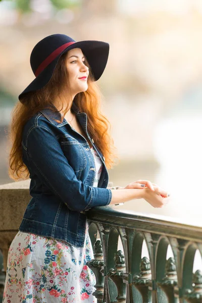 Ritratto della bella ragazza alla moda con cappello su argine in giorno estivo — Foto Stock